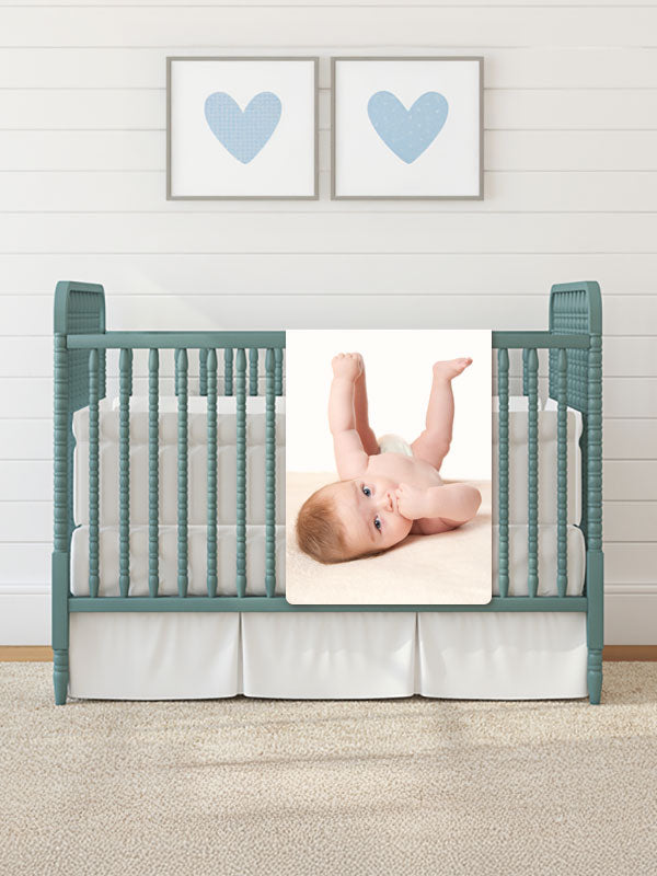 personalized baby blanket laying over crib